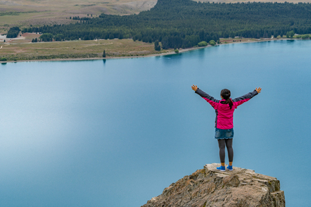 Woman traveller enjoys scenic view of lake Tekapo landscape in New Zealand.の写真素材