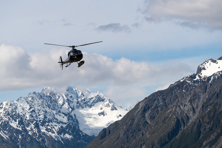 Mt Cook, New Zealand - Dec 4, 2016: Tourist helicopter flys in the mountain area in Mt Cook National Park, New Zealand. The helicopter service offers scenic flights, glacier landing, emergency rescue.のeditorial素材