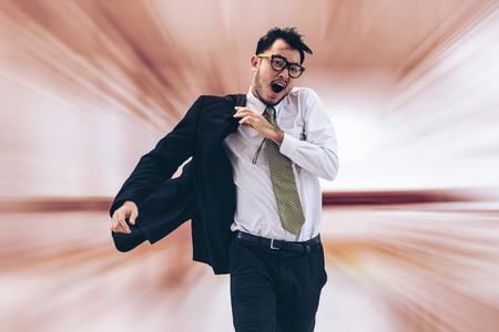 Rushing businessman running, or racing with time on street in rush hour. Business man running late for work or racing with competitors. Concept of fast life, racing business and business competition.の写真素材