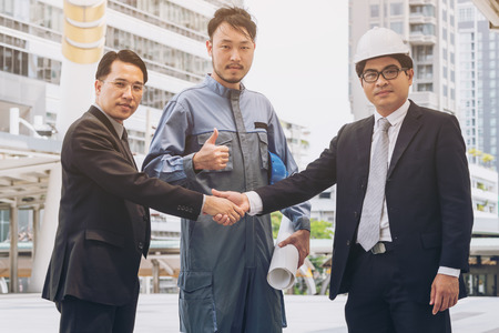 Business man handshake with engineer thumbs up. Success in engineering project. Architectural project achievement .の写真素材