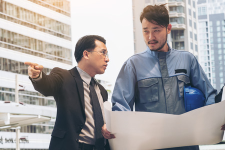 Engineer, architect, business man discuss on engineering blueprint drawing. Concept of architecture, construction engineering and business people group meeting.の写真素材