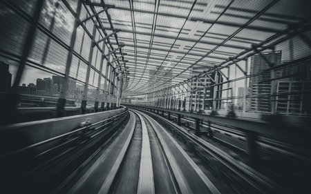Front view of train moving in city rail tunnel with moderate motion blur in black and white filter. Transportation concept and motion blur background abstract.の写真素材