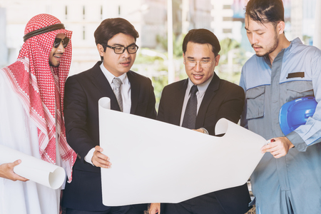 Engineer, businessmen and Arab man meeting about construction drawing discussion. Multicultural oversea engineering business concept.の写真素材