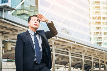 Business man looking away in the modern city view, anticipating business future. Concept of CEO leader, leadership and business visions.の写真素材