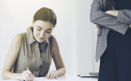 Young woman employee and manager in meeting at office. The manager is giving advice to the new employee.の写真素材