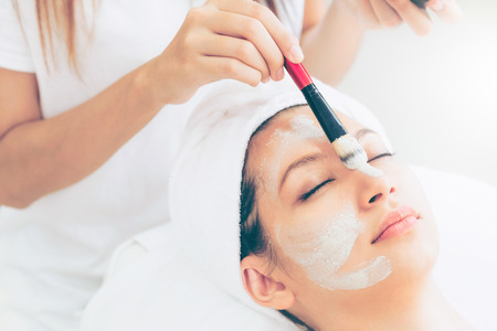 Beautiful woman having a facial cosmetic scrub treatment from professional dermatologist at wellness spa. Anti-aging, facial skin care and luxury lifestyle concept.の写真素材