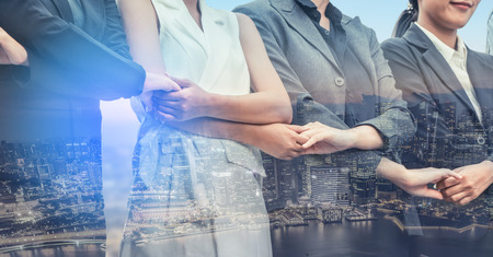 Double exposure business people holding hands together showing workers relationship, unity and teamwork. Human resources and people recruitment concept.の写真素材