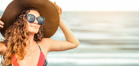 Happy young woman wearing swimsuit having good time at tropical beach in summer for holiday travel vacation.の写真素材