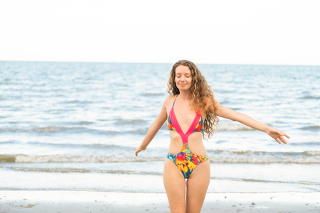 Happy young woman wearing swimsuit having good time at tropical beach in summer for holiday travel vacation.の写真素材