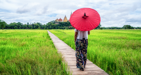 Woman traveller hiking in Asian rice field landscape. Backpacking vacation in spring season.の写真素材