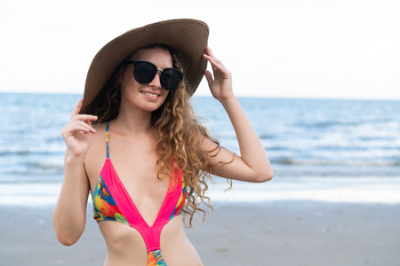 Happy young woman wearing swimsuit having good time at tropical beach in summer for holiday travel vacation.の写真素材