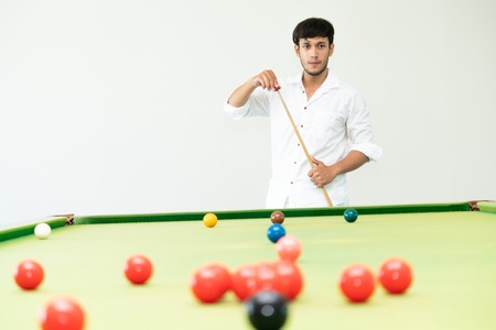 Young man playing snooker in the sport club.の写真素材