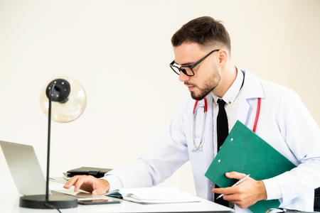 Doctor at office table in the hospital with patient health file. Medical and healthcare concept.の写真素材