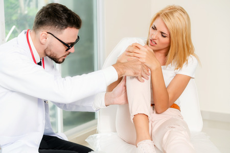 Male doctor is examining female patient in hospital ward. Healthcare and medical service.の写真素材