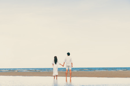 Happy couple going honeymoon travel on tropical sand beach in summer.の写真素材