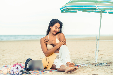 Plus size young woman sitting on tropical sand beach in summer. Holiday travel vacation.の写真素材