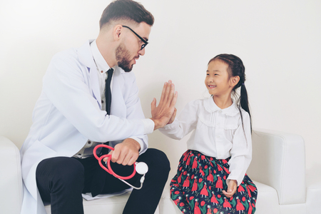 Little kid visit doctor in hospital office. The kid is happy and not afraid of the doctor. Medical and children healthcare concept.の写真素材