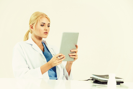 Woman doctor in hospital or healthcare institute working on medical report at office table.の写真素材