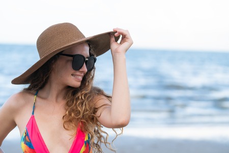 Happy young woman wearing swimsuit having good time at tropical beach in summer for holiday travel vacation.の写真素材