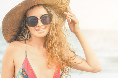 Happy young woman wearing swimsuit having good time at tropical beach in summer for holiday travel vacation.の写真素材