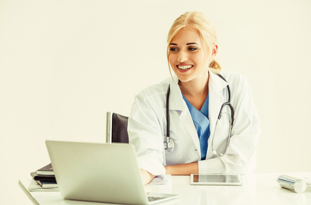 Woman doctor in hospital or healthcare institute working on medical report at office table.の写真素材