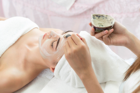 Beautiful woman having a facial cosmetic scrub treatment from professional dermatologist at wellness spa. Anti-aging, facial skin care and luxury lifestyle concept.の写真素材