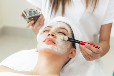 Beautiful woman having a facial cosmetic scrub treatment from professional dermatologist at wellness spa. Anti-aging, facial skin care and luxury lifestyle concept.の写真素材
