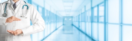 Male doctor at hospital opening hand palm to build copy space for your text and design. Medical healthcare business and doctor service.の写真素材
