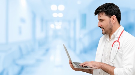 Doctor using laptop computer at the hospital. Medical healthcare and doctor staff service.の写真素材