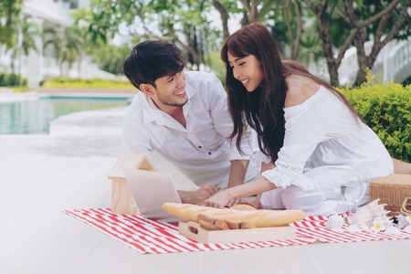 Happy young couple go picnic and dating at the park in summer.の写真素材