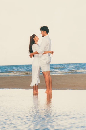 Happy couple going honeymoon travel on tropical sand beach in summer.