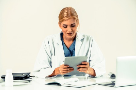 Woman doctor in hospital or healthcare institute working on medical report at office table.の写真素材