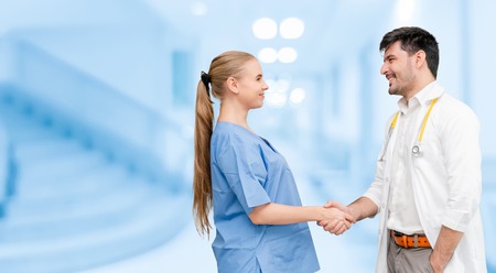 Doctor in hospital handshake with another doctor. Healthcare people teamwork and medical service concept.の写真素材