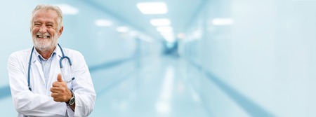 Happy senior doctor standing in the hospital. Medical healthcare business and doctor service.の写真素材