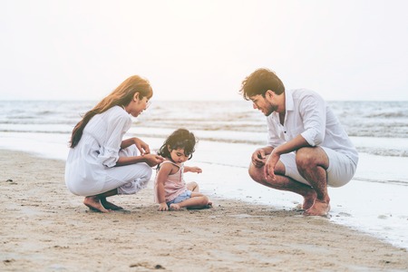 Happy family of father, mother and kids goes vacation on a tropical sand beach in summer.の写真素材