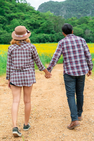Happy couple take a romantic walk in green grass field on the hills. Travel and honeymoon concept.の写真素材