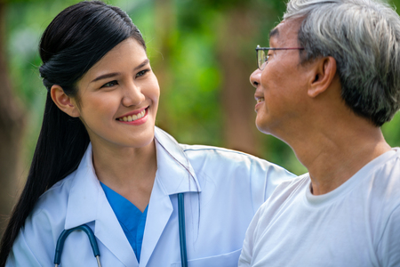 Friendly doctor taking care of senior man in the hospital garden. Medical and healthcare doctor service concept.の写真素材