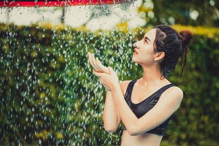 Young woman taking shower at swimming pool in luxury resort hotel. Travel and summer lifestyle.の写真素材