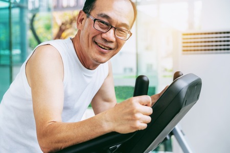 Senior man exercise on treadmill in fitness center. Mature healthy lifestyle.の写真素材