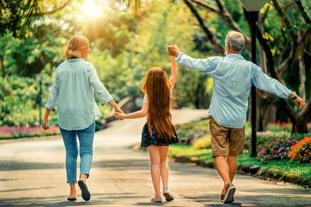 Happy healthy family walk together on path in the park in summer. Concept of family bonding.の写真素材