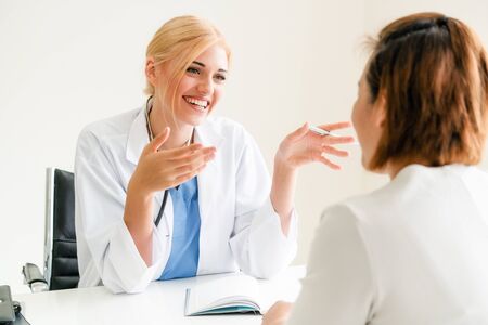 Woman doctor is talking and examining female patient in hospital office. Healthcare and medical service.の写真素材