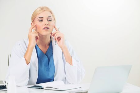 Woman doctor in hospital or healthcare institute working on medical report at office table.の写真素材