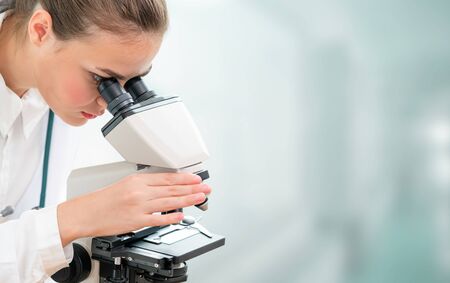Scientist researcher using microscope in laboratory. Medical healthcare technology and pharmaceutical research and development concept.の写真素材