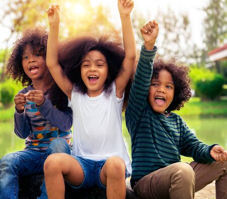 Happy African American boy and girl kids group playing in the playground in school. Children friendship and education concept.の写真素材
