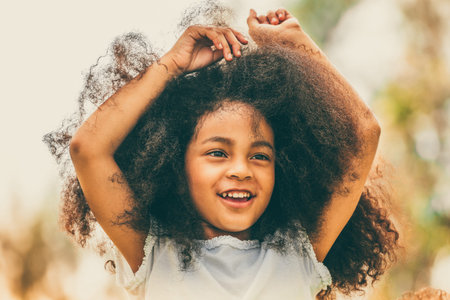 Portrait of happy African American child playing in outdoors park. Freedom and children health concept.の写真素材