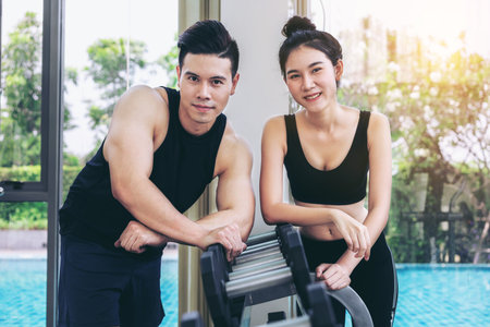 Healthy man and woman doing weight training in gym fitness center. Bodybuilding concept.