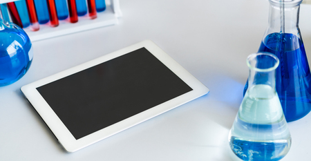 Tablet computer in laboratory and biochemistry sample in test tube. Science technology research and development study concept.の写真素材