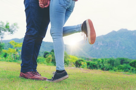 Happy couple take a romantic walk in green grass field on the hills. Travel and honeymoon concept.の写真素材