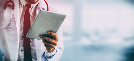 Doctor using tablet computer at the hospital. Medical healthcare and doctor staff service.の写真素材