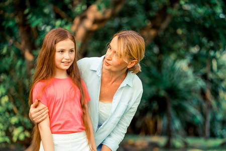 Relaxed happy mother and little kid daughter in outdoors public park. Parenthood and child concept.の写真素材